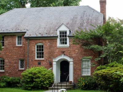 A brick house with a car parked in front of it