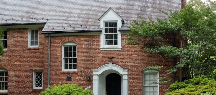 A brick house with a car parked in front of it