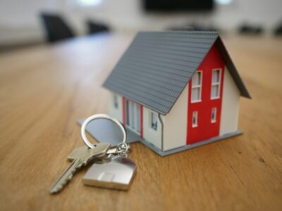 Miniature house with keys on table, displayed above 